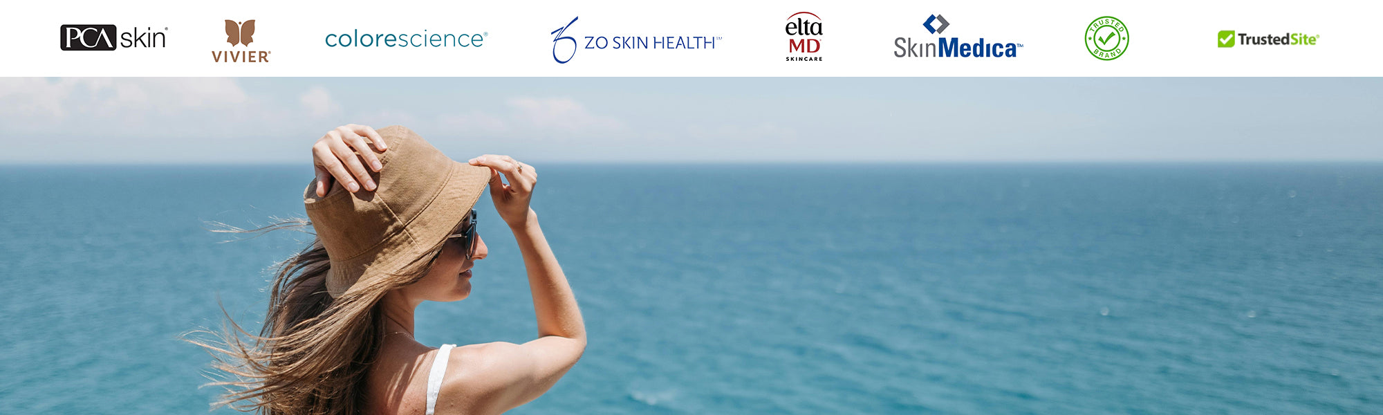 Woman in sun hat enjoying coastal view symbolizing summer skincare protection with Skin Boutique Online.