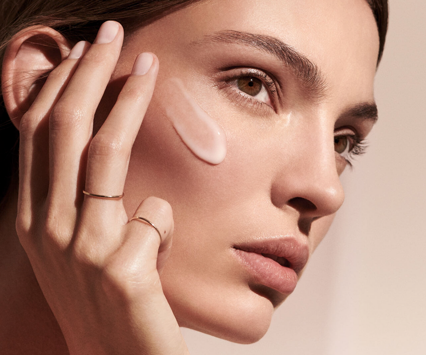 Woman applying SkinMedica TNS Advanced+ Serum to face for anti-aging benefits